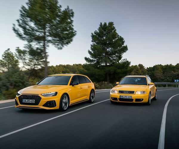 Yellow Audi RS4 Avant edition 25 years and yellow RS4 Avant driving down a road side by side.