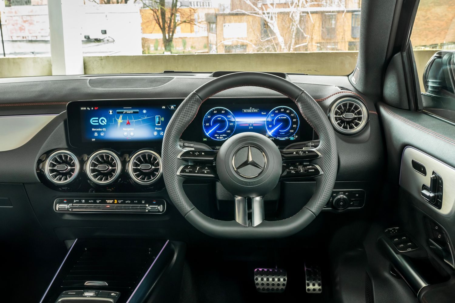 Mercedes-Benz EQA steering wheel, dual infotainment displays and silver air vents.