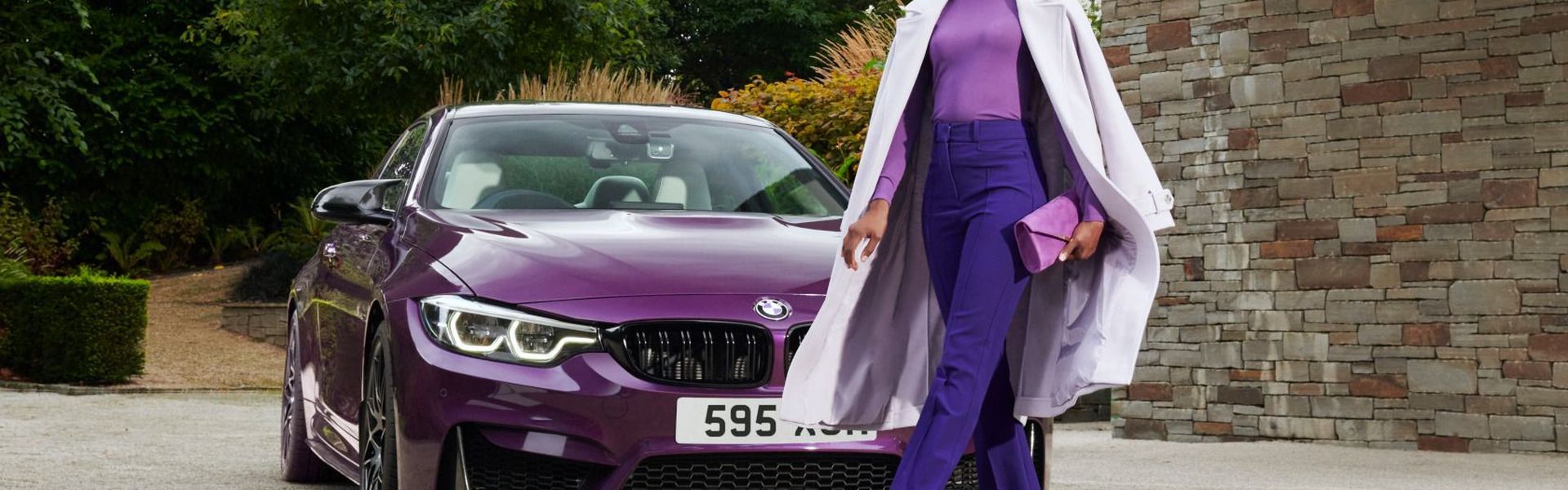 Woman walking in front of a BMW advertising the BMW personalised pricing plan.