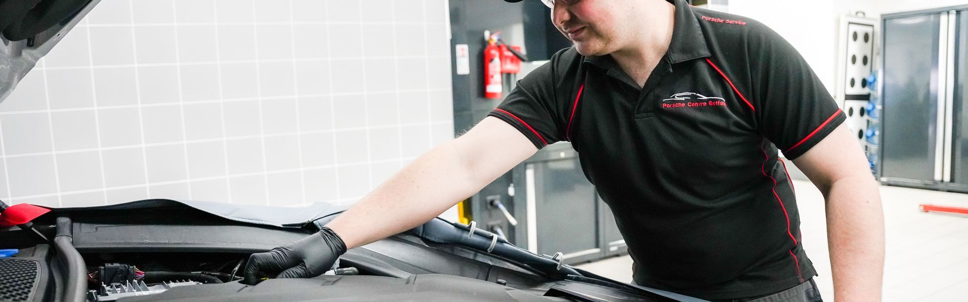 Porsche Repair Specialist inspects the engine of a Porsche vehicle for repairs at the Porsche Approved Repair Centre at Porsche Centre Belfast