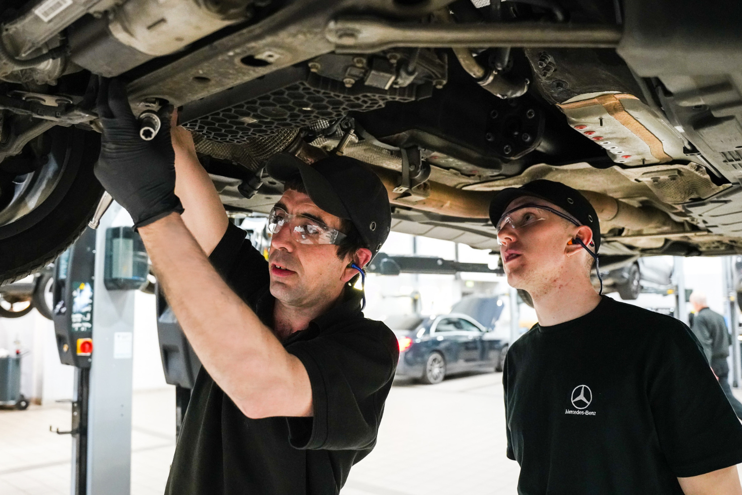 Apprentice Motor Vehicle Technician watches technician repair vehicle