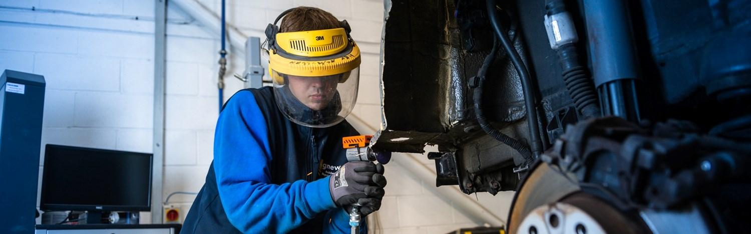 Agnew Repair Centre Technician wearing protective equipment sands a Volvo vehicle during repair and maintenance work.