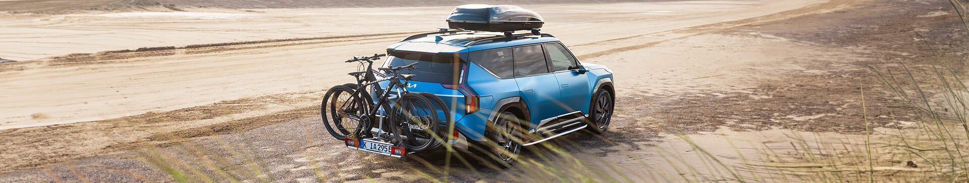 Blue KIA SUV with a Roof Rack and Bike Rack