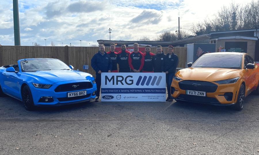 MRG Chippenham with Corsham Town FC players and directors, plus blue ford Mustang V8 and Orange Ford Mustang Mach-e GT