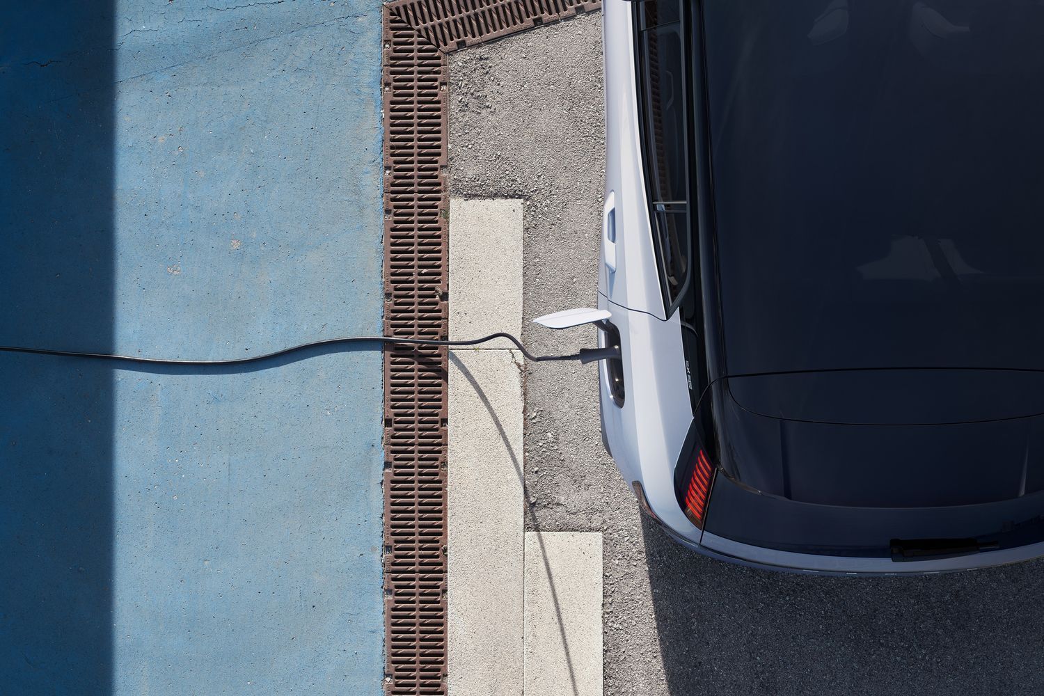 Aerial view of the all new Volvo EX30 in grey, parked and charging in car park