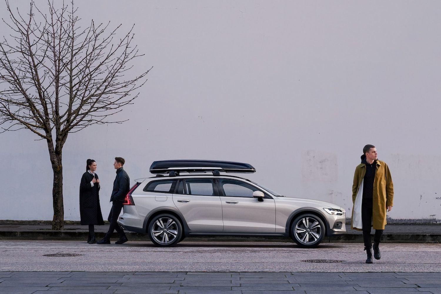 Volvo XC90 with Travel Pack is parked to the side of a snowy road with passengers walking away from the vehicle