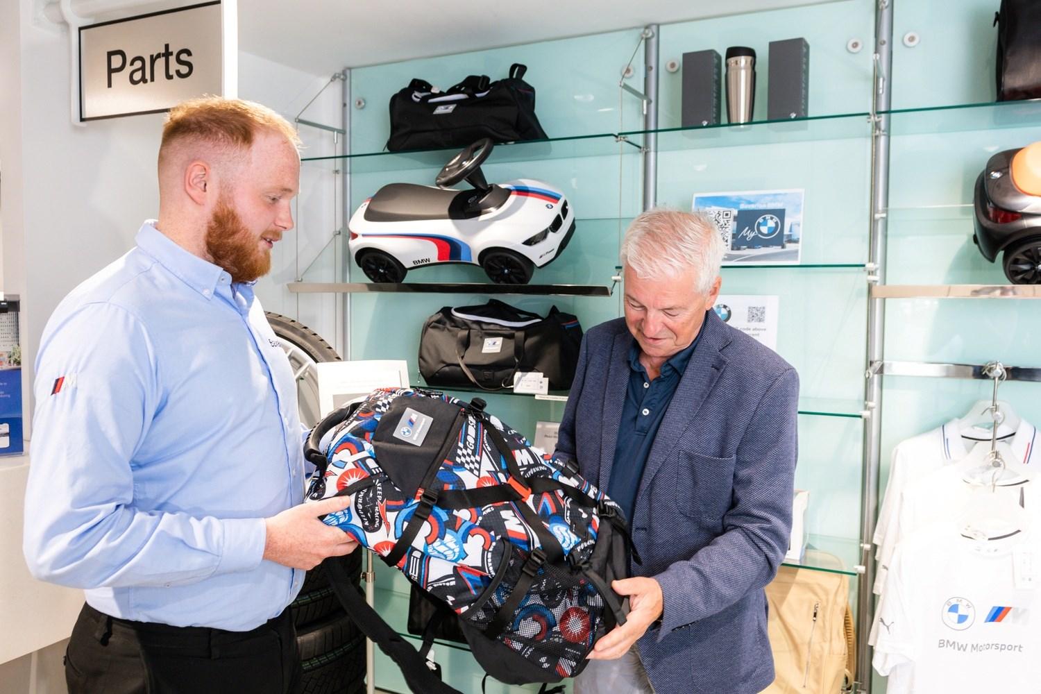 BMW Sales Specialist shows customer the latest BMW Backpack while at the BMW Boutique in Bavarian BMW, Belfast.