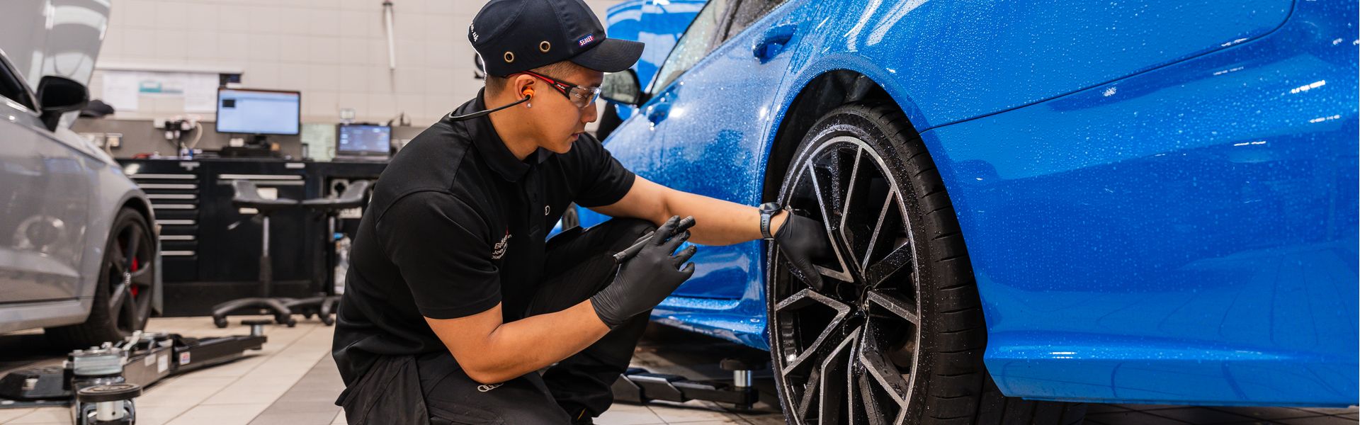 Audi Technician inspects wheel during routine maintenance at Belfast Audi