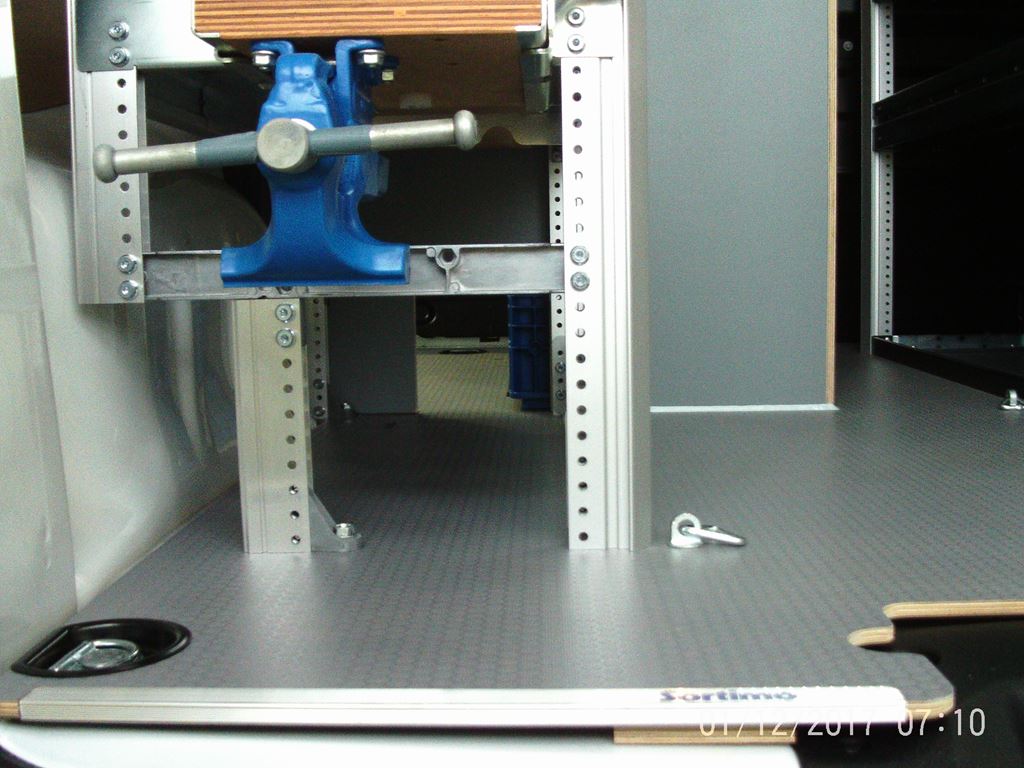 Low angle view of van workshop floor with bench vice mounted to the racking frame.