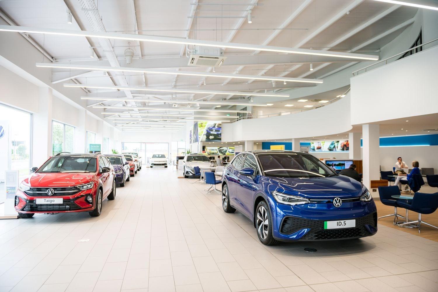 The Agnew Volkswagen Belfast showroom featuring some of the latest range of Volkswagen new cars. On display, is a blue Volkswagen ID.5 and a red Volkswagen Taigo.