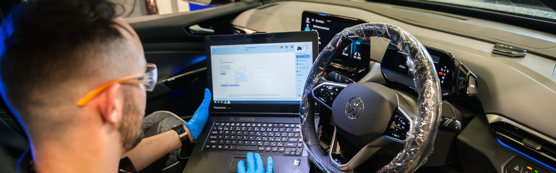 Volkswagen Technician conducts initial diagnostic scan on vehicle during maintenance work