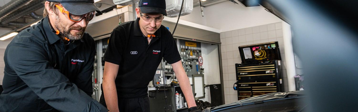 Two Audi Repair Specialists look under the hood during routine maintenance on an Audi A8 at Portadown Audi
