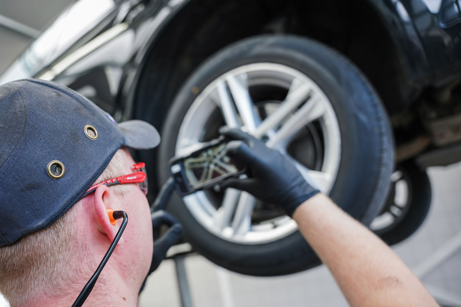 MINI Repair Specialist takes photo of wheel for closer inspection at the MINI Repair Centre at Bavarian MINI