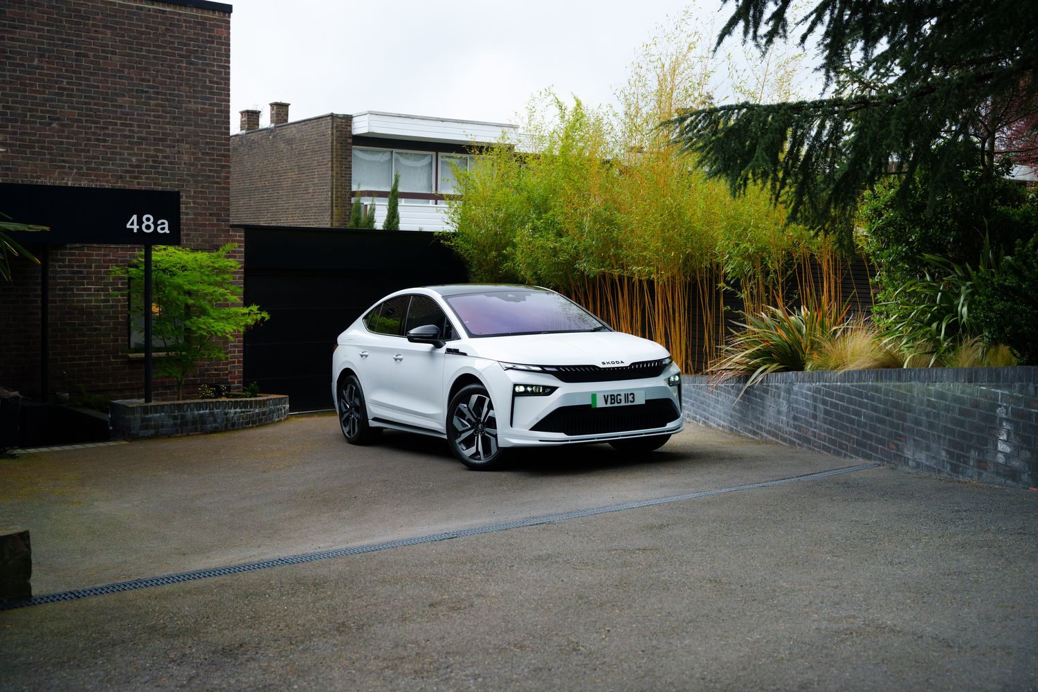 The new Skoda Enyaq Coupe Sportline, available at Agnew Skoda Belfast and Mallusk. Front view of the Enyaq Coupe parked outside home.