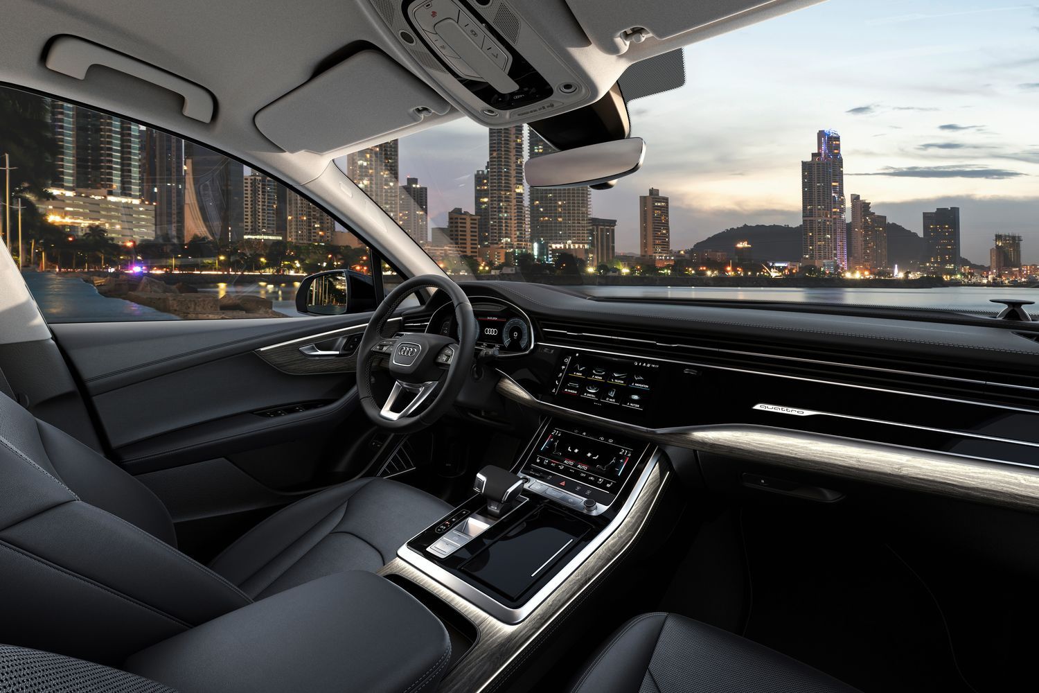 View from the passenger side of the Audi Q7 TFSI E black leather interior and driver displays.