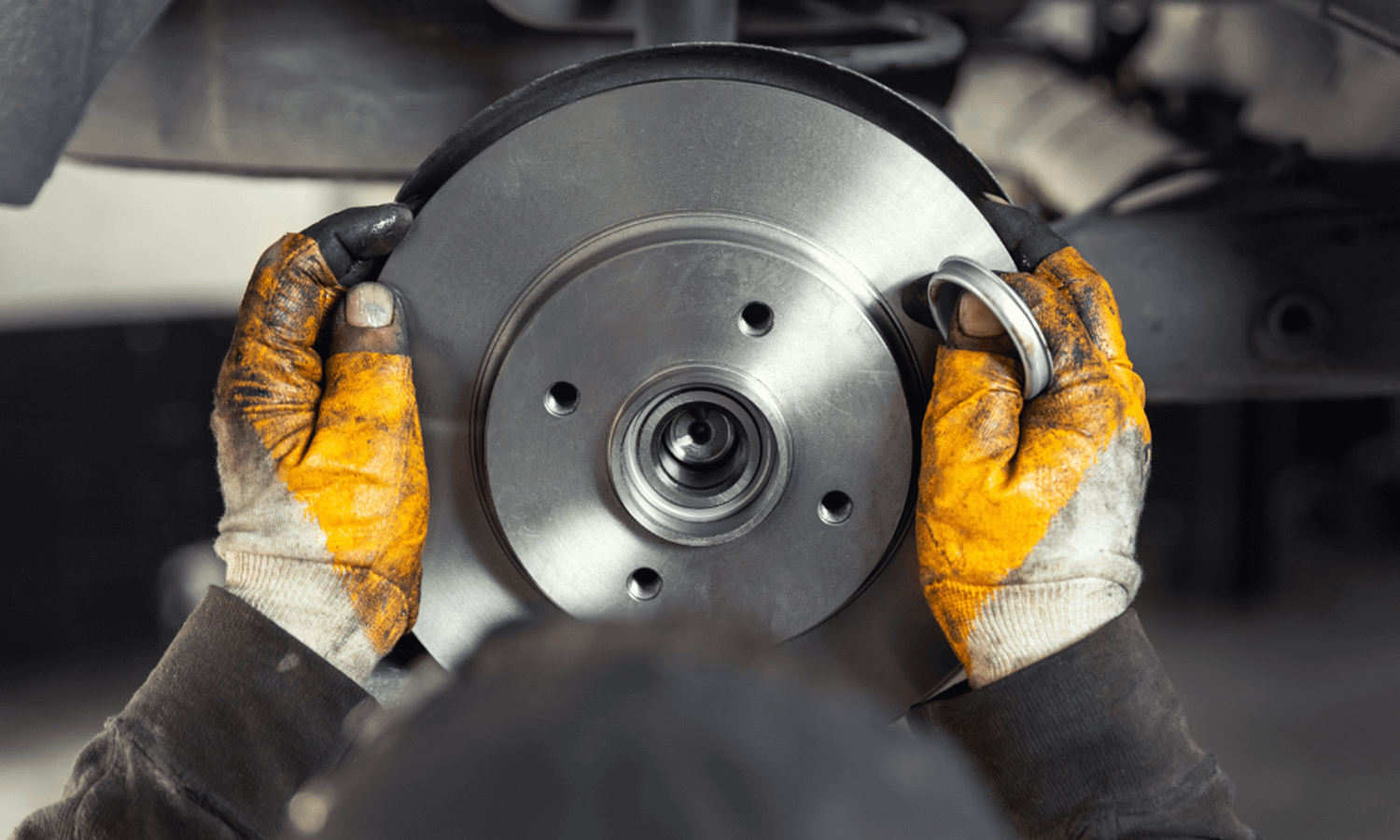 mechanic fitting brake discs and pads to a car