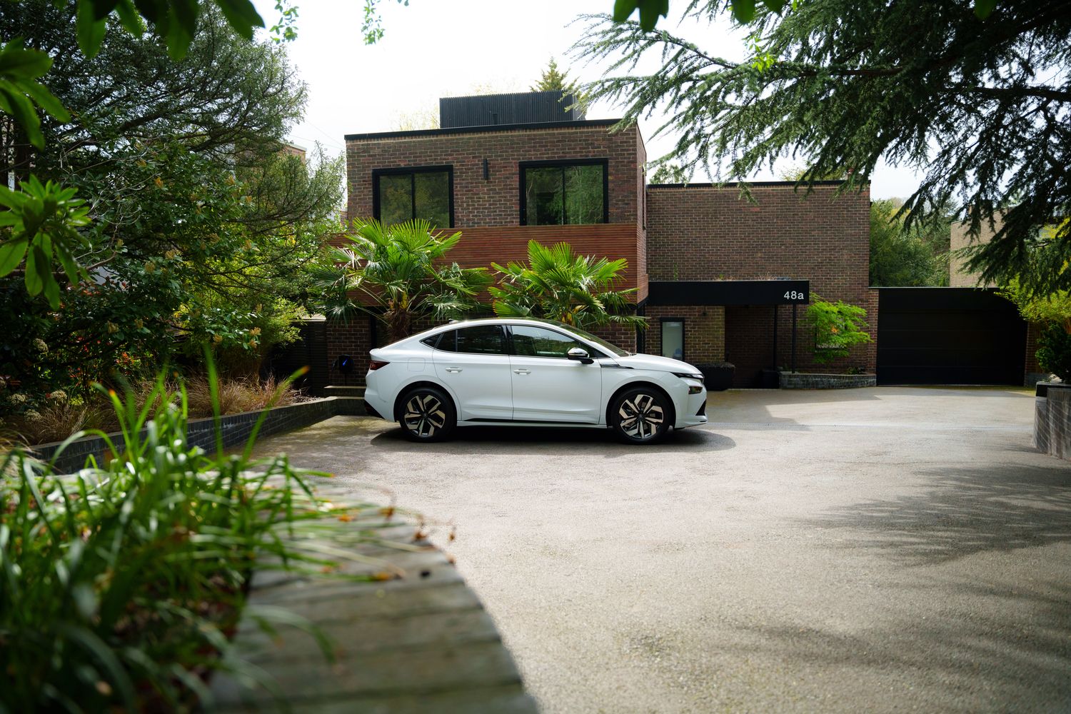 Side view of the Skoda Enyaq Coupe, parked outside home.