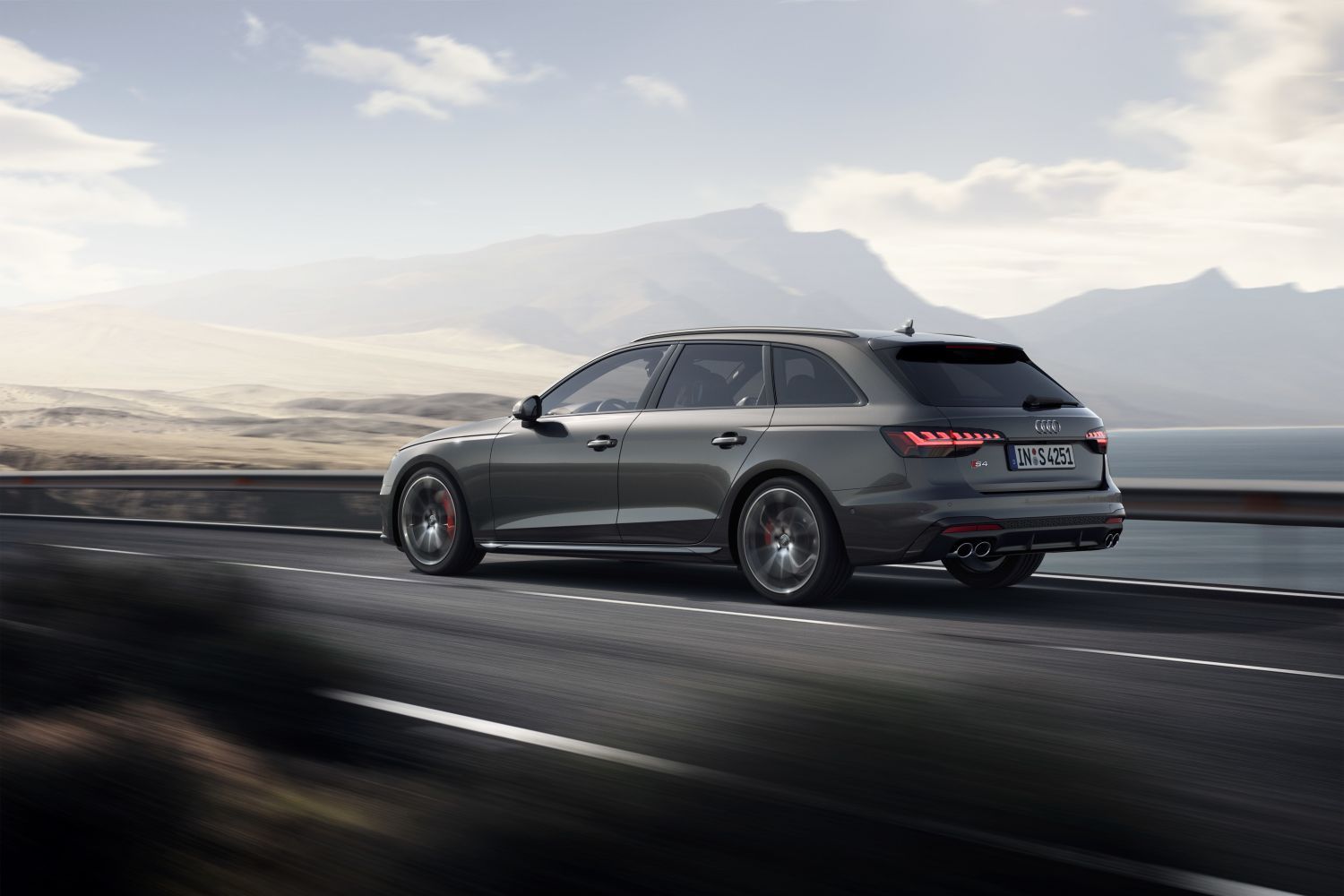 New Audi A4 S4 Avant in metallic grey driving on a road.