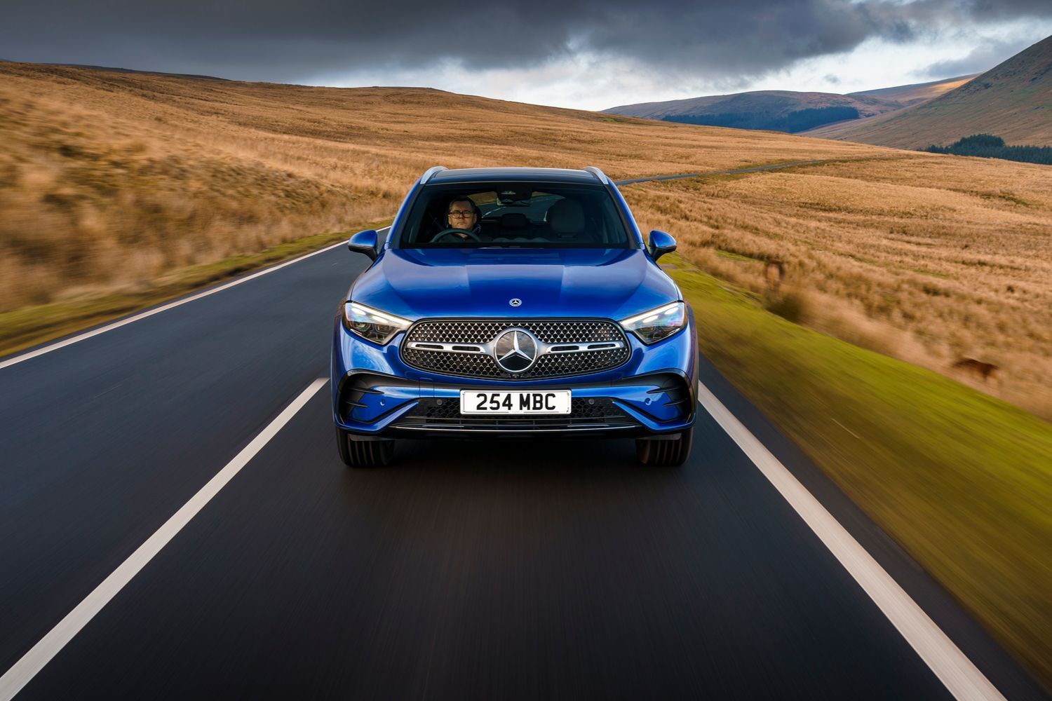 Front view of a blue Mercedes-Benz GLC driving.