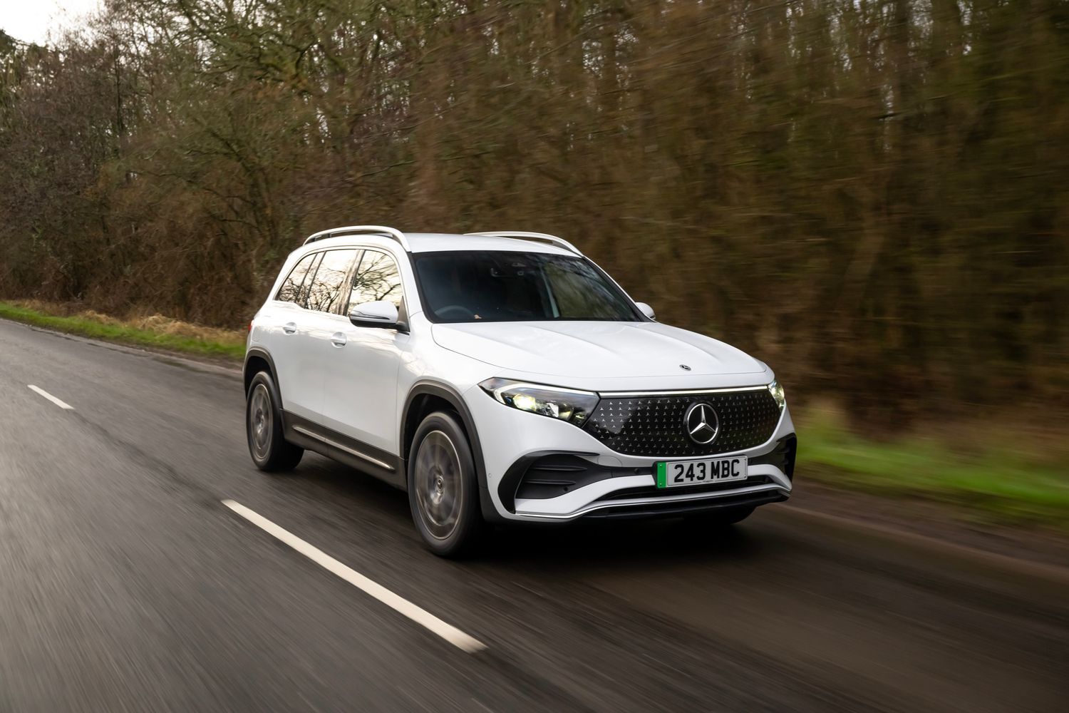 A white Mercedes-Benz EBQ driving.