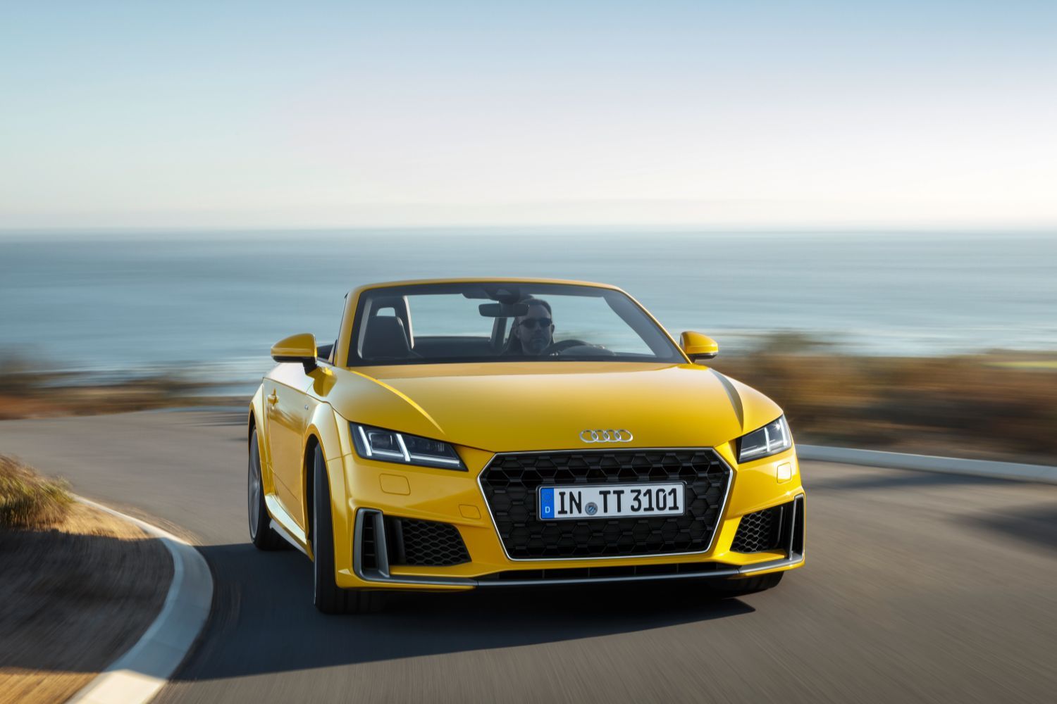 New Audi TT Roadster in yellow, image of vehicle driving from the front