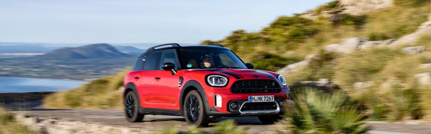 New MINI Countryman drives along country road with mountains and sea behind