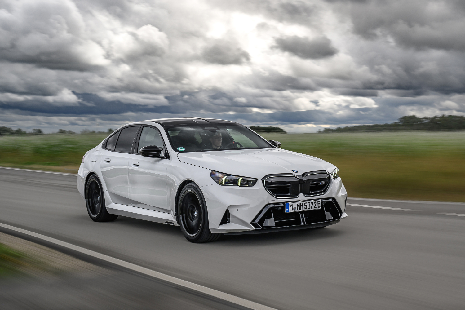 The new BMW M5 Saloon driving fast along country roads.