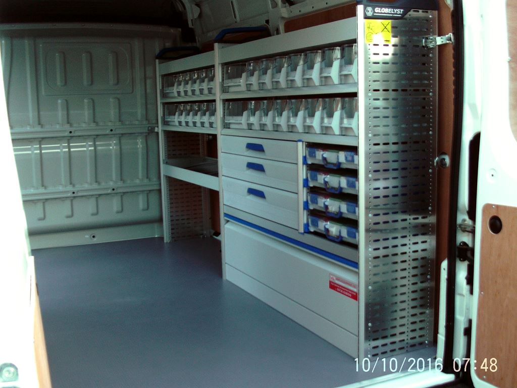 Work van conversion with racking, drawers and stacked storage bins along the side wall.