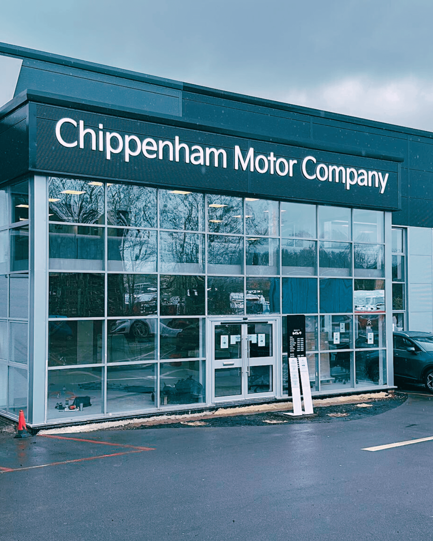 New Chippenham Motor Company signs above the dealership building door