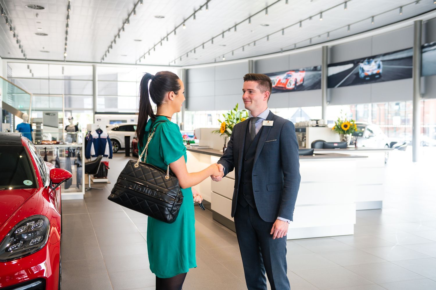 Porsche Sales Specialist shakes customers hand inside the showroom at Porsche Centre Belfast, Northern Ireland.