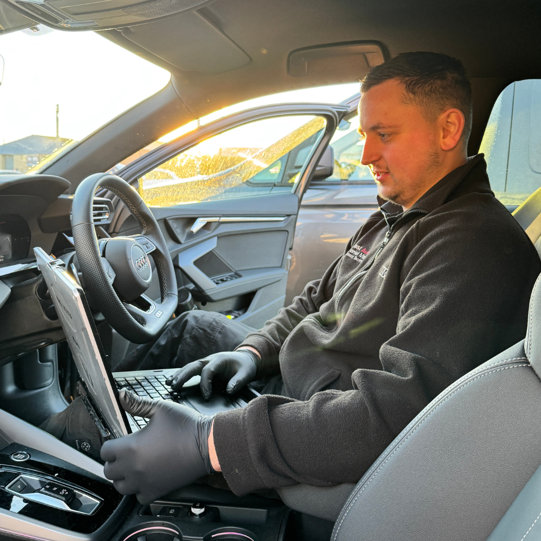 An Audi Mobile support technician performing a service on a customers vehicle.