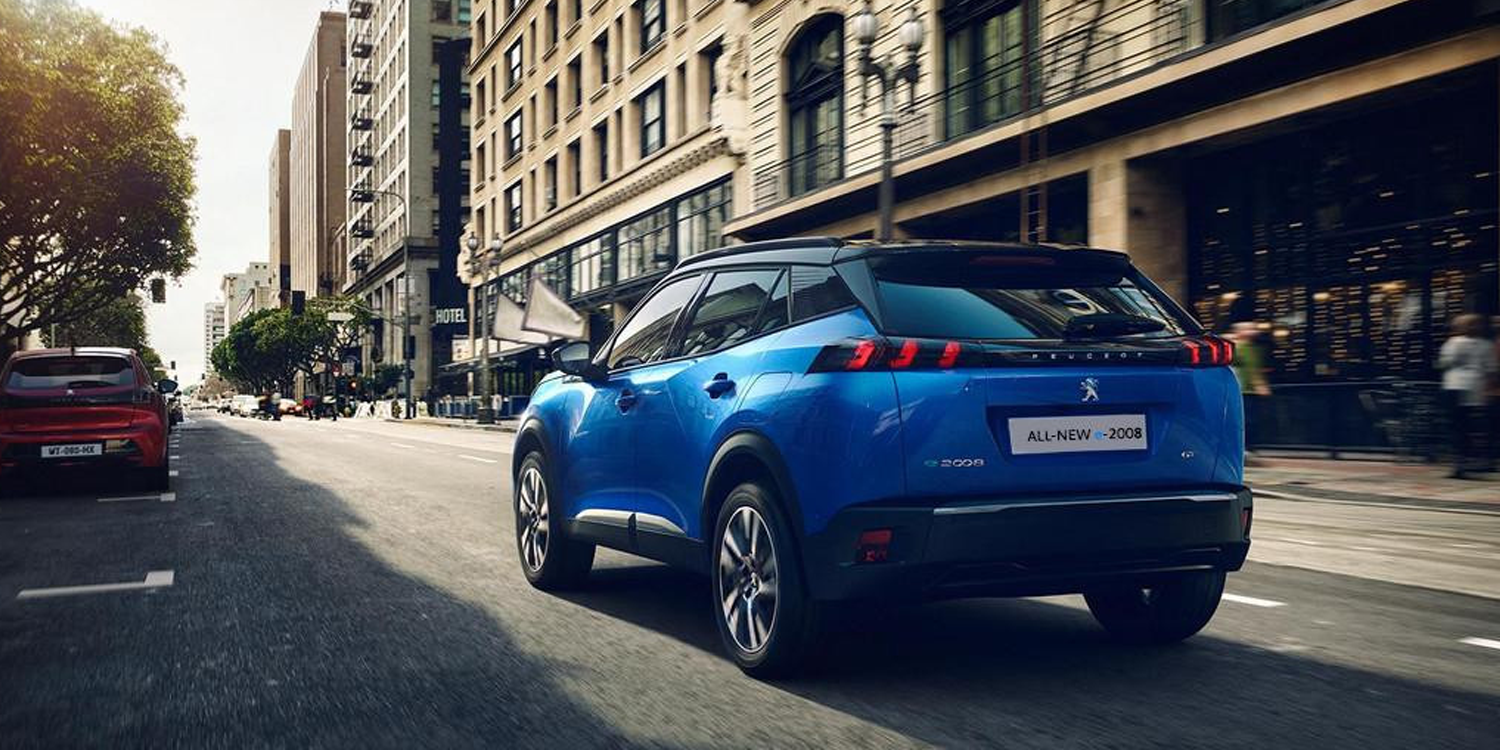 Blue Peugeot 2008 driving down street