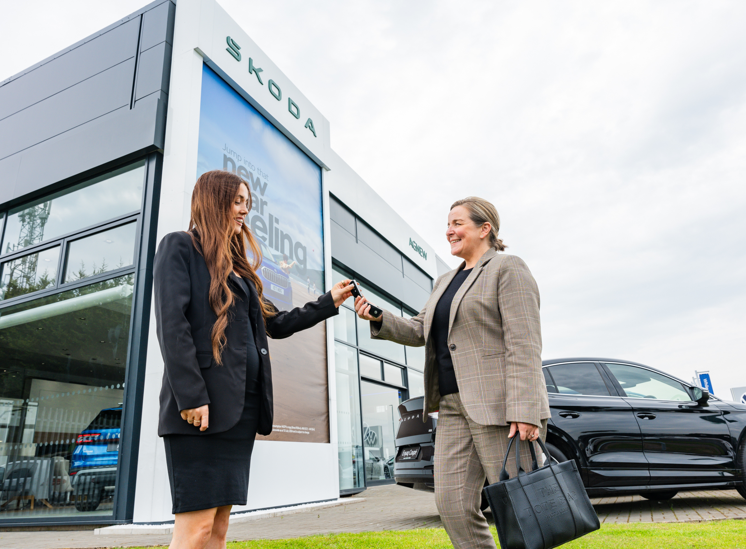 Sales team member handing over keys to Skoda Belfast customer