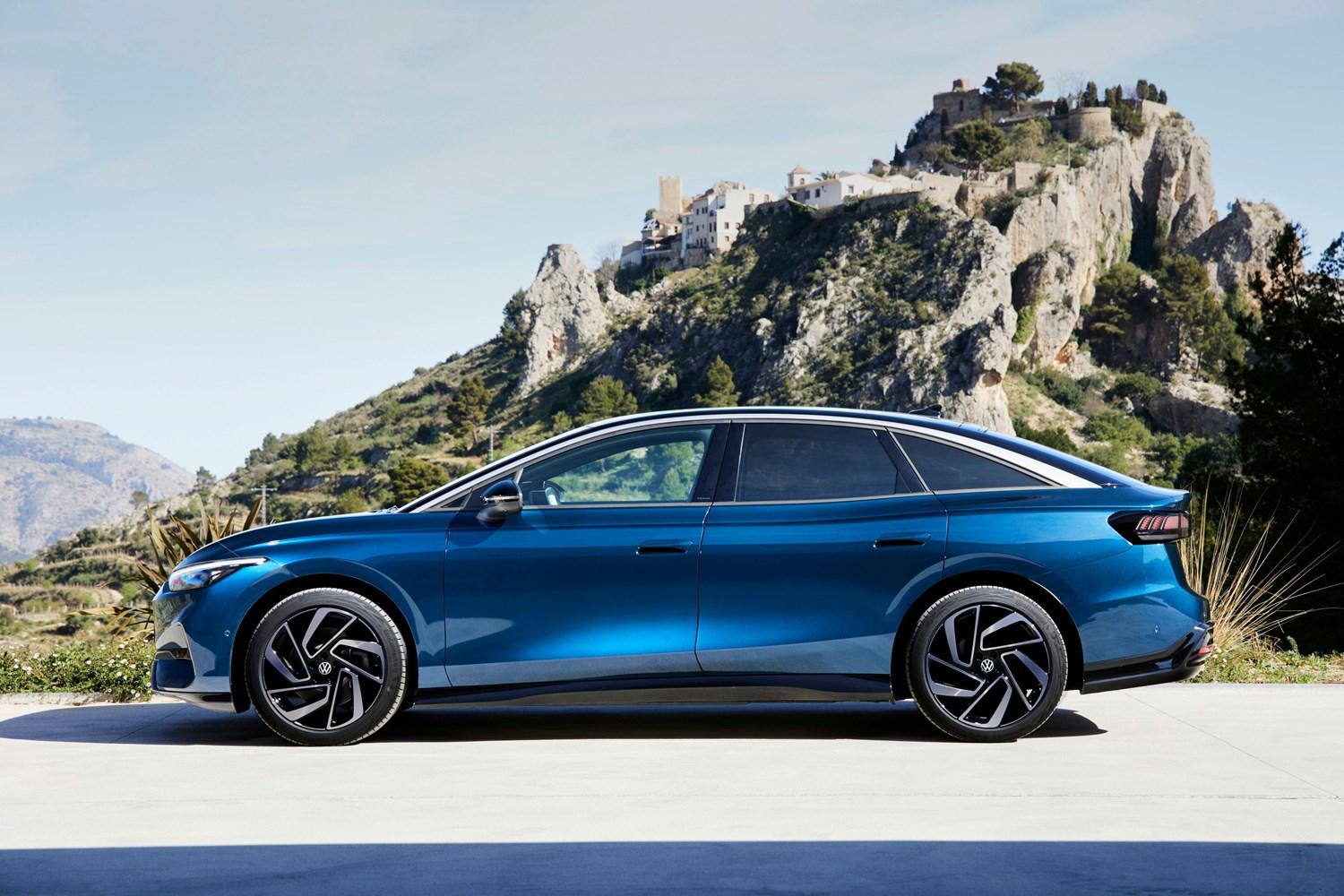 Side view of the new Volkswagen ID.7 in blue, parked with rocky hill behind