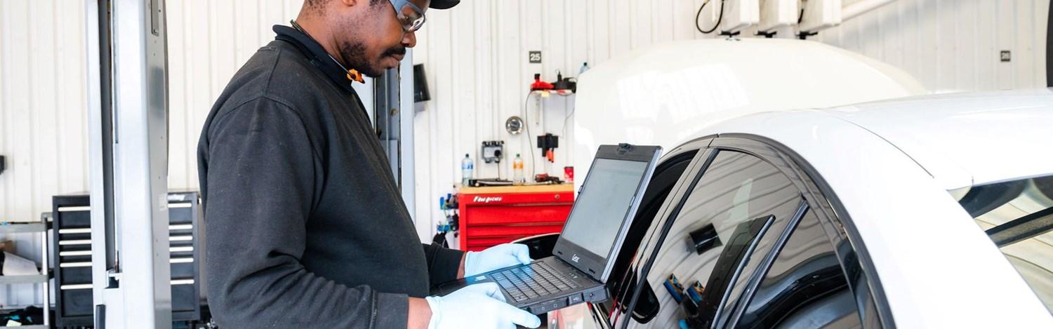BMW Technician checks laptop for repair information ahead of BMW vehicle repair at Bavarian BMW Belfast