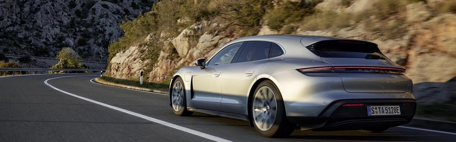 grey Porsche Panamera Turbo E-Hybrid drives along rocky cliff road