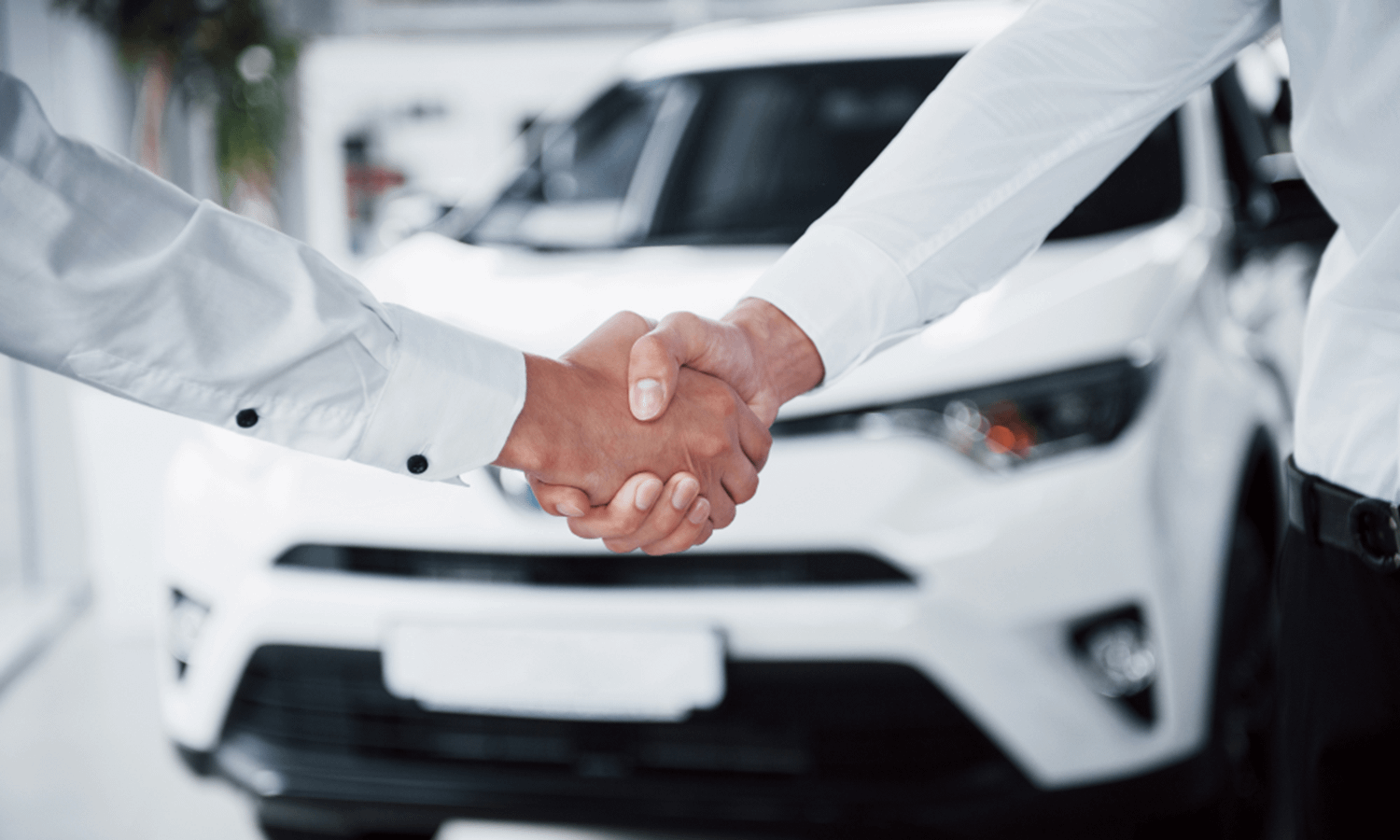 Shaking hands after selling a white car
