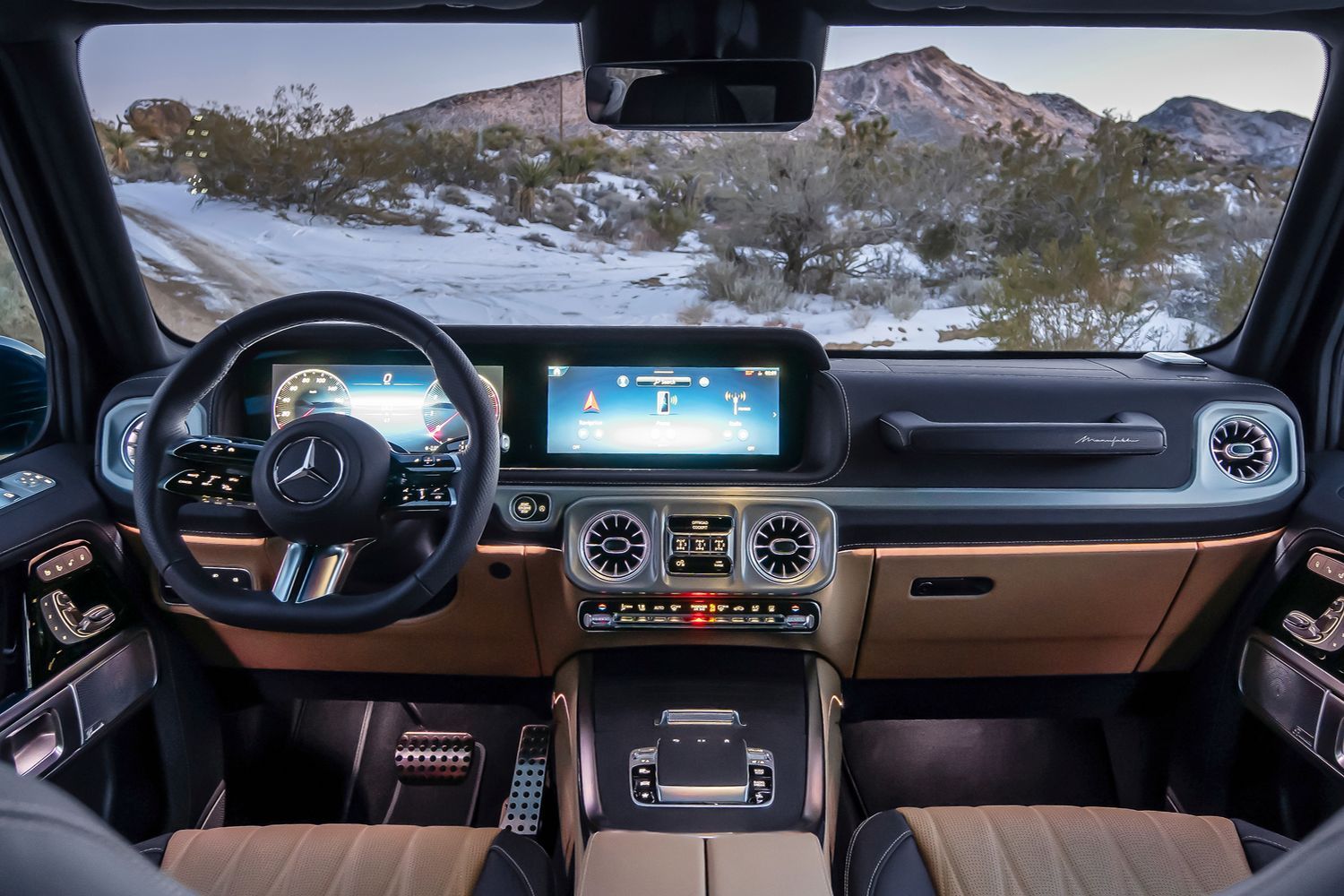 The new Mercedes-Benz G-Class tan and black interior with steering wheel and two driver displays.
