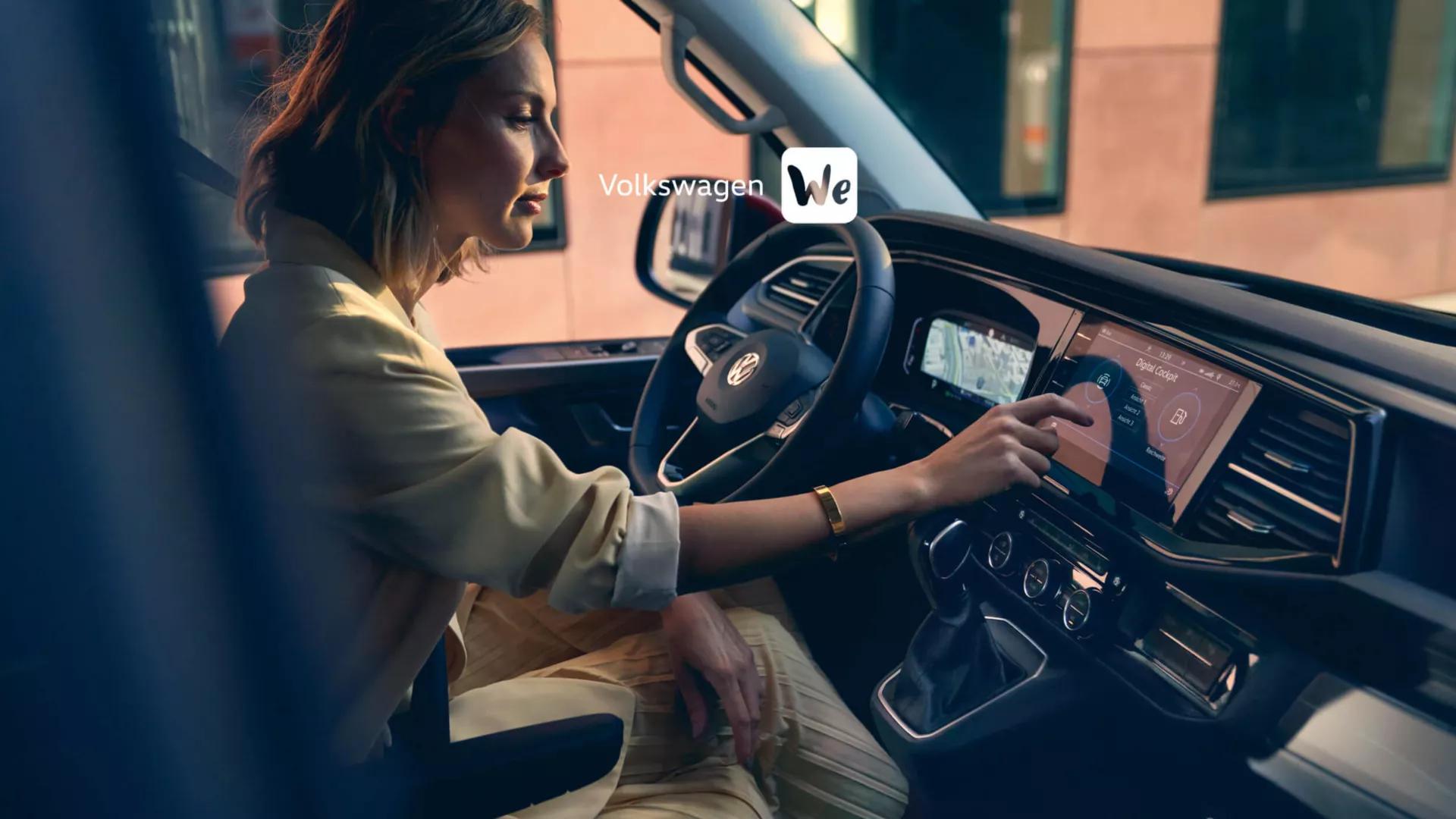 Interior view of a Volkswagen Golf with the driver selecting features on the main central console. The words 'Volkswagen We' are present on top of the image.