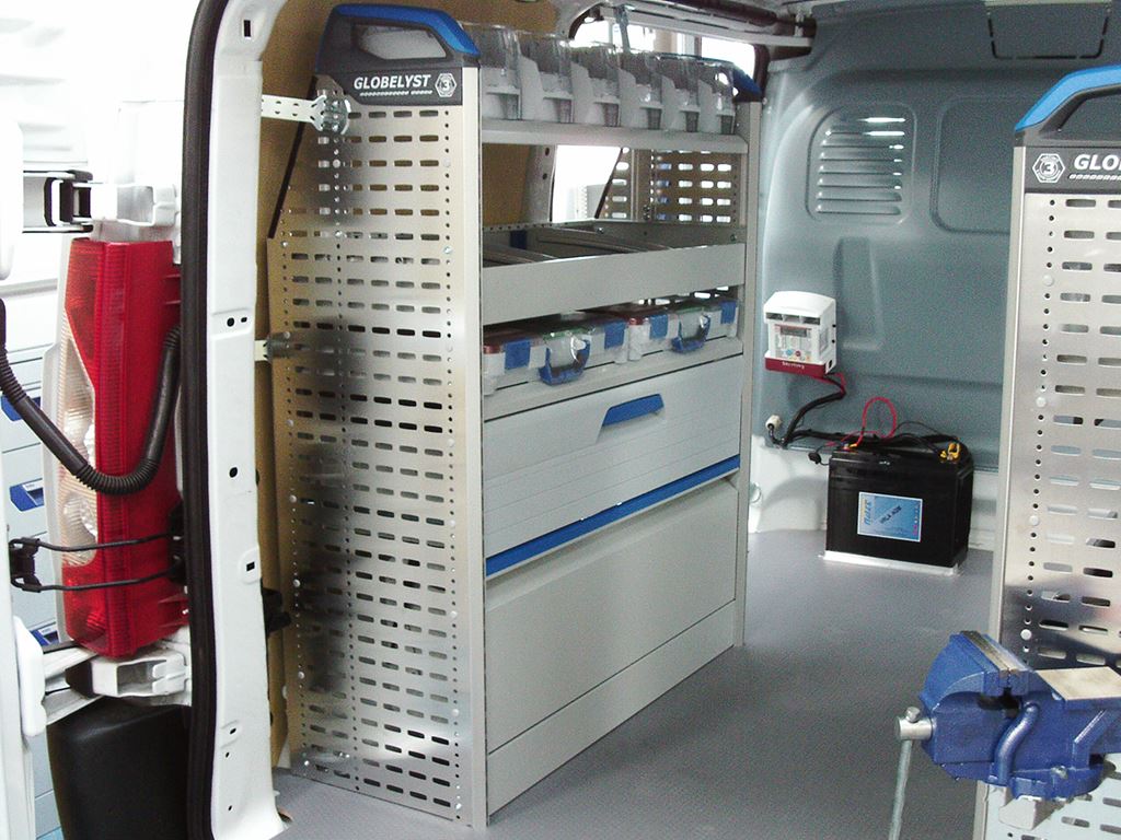 Work van interior with racking system, storage drawers, battery unit and bench vice.