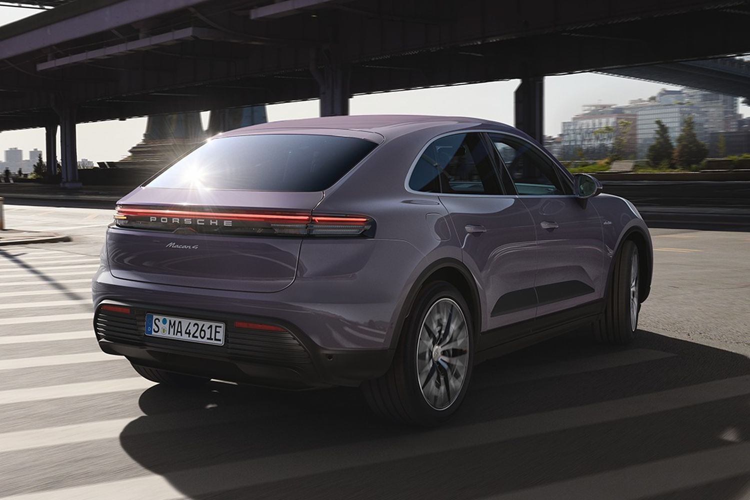 Rear of the all-new Porsche Macan in purple driving along New York street