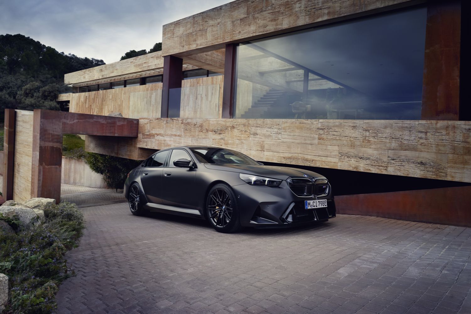 The new BMW M5 Saloon, parked at modern home.