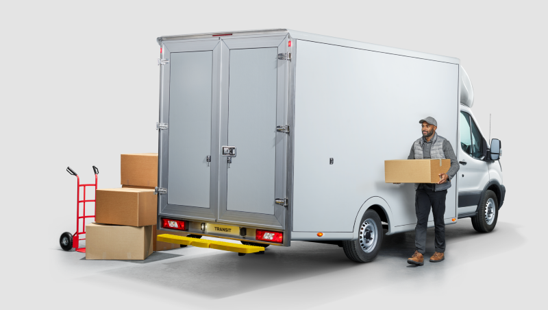 Worker loading parcels onto white Ford Transit One Stop Shop