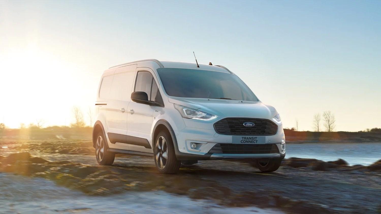 White Ford Transit Connect driving next to lake