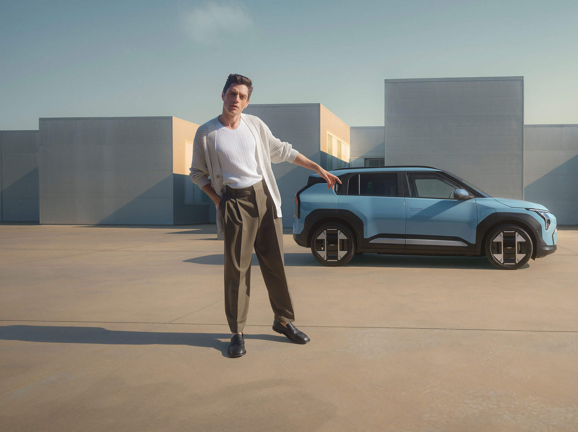 man standing infront of a blue kia ev3