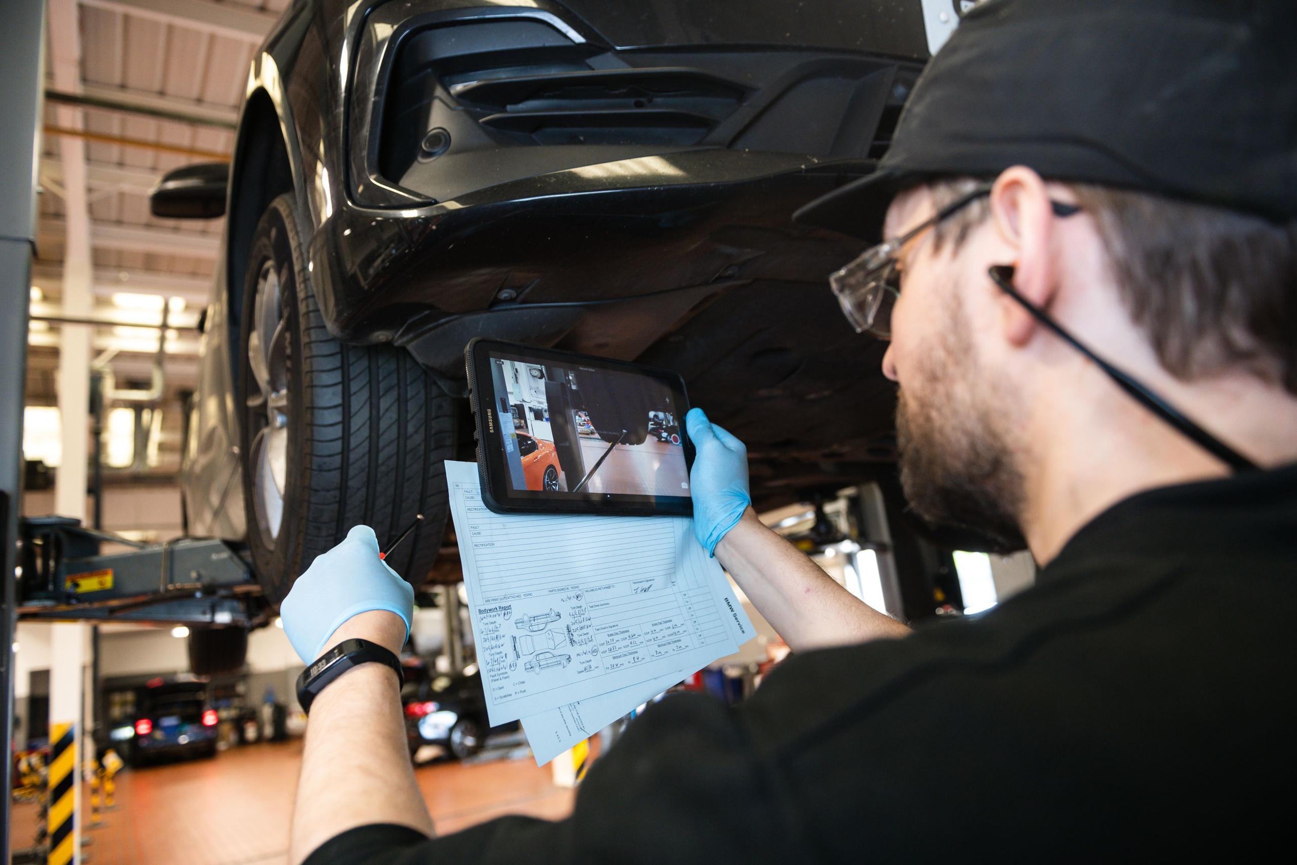 Technician inspects the wheel tread on Motability vehicle getting serviced