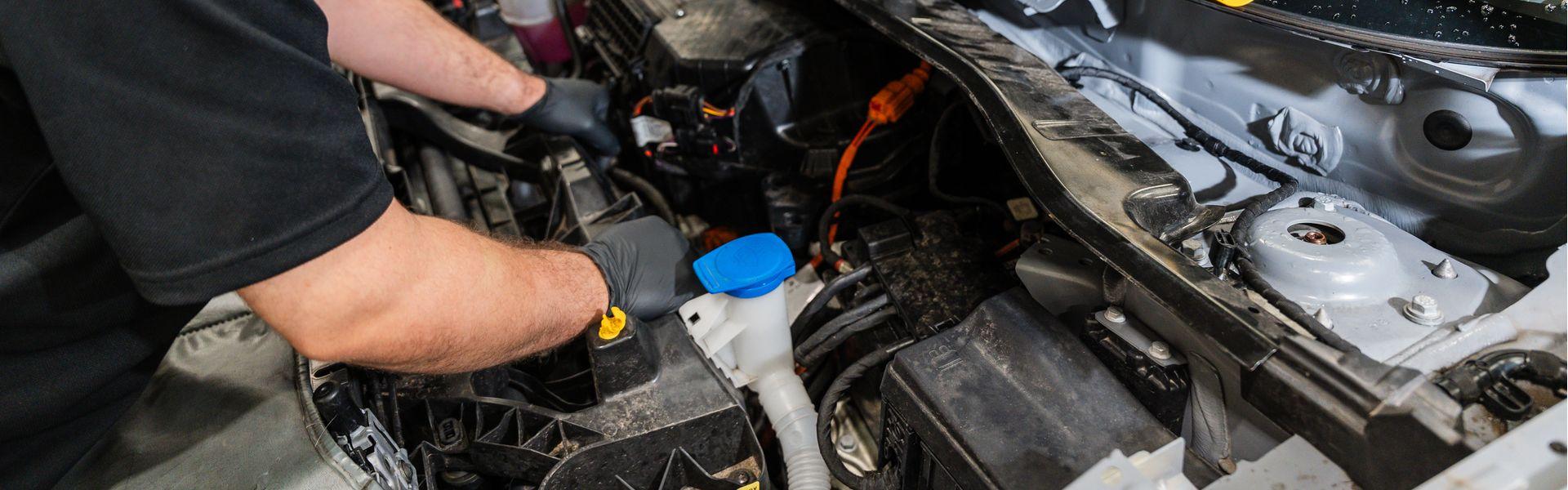 Audi Technician inspects under the bonnet of car