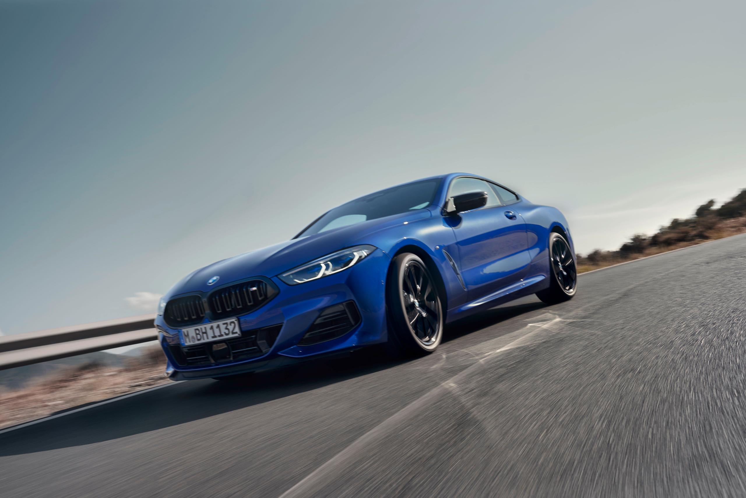New BMW 8 Series Coupe in blue front view of vehicle driving