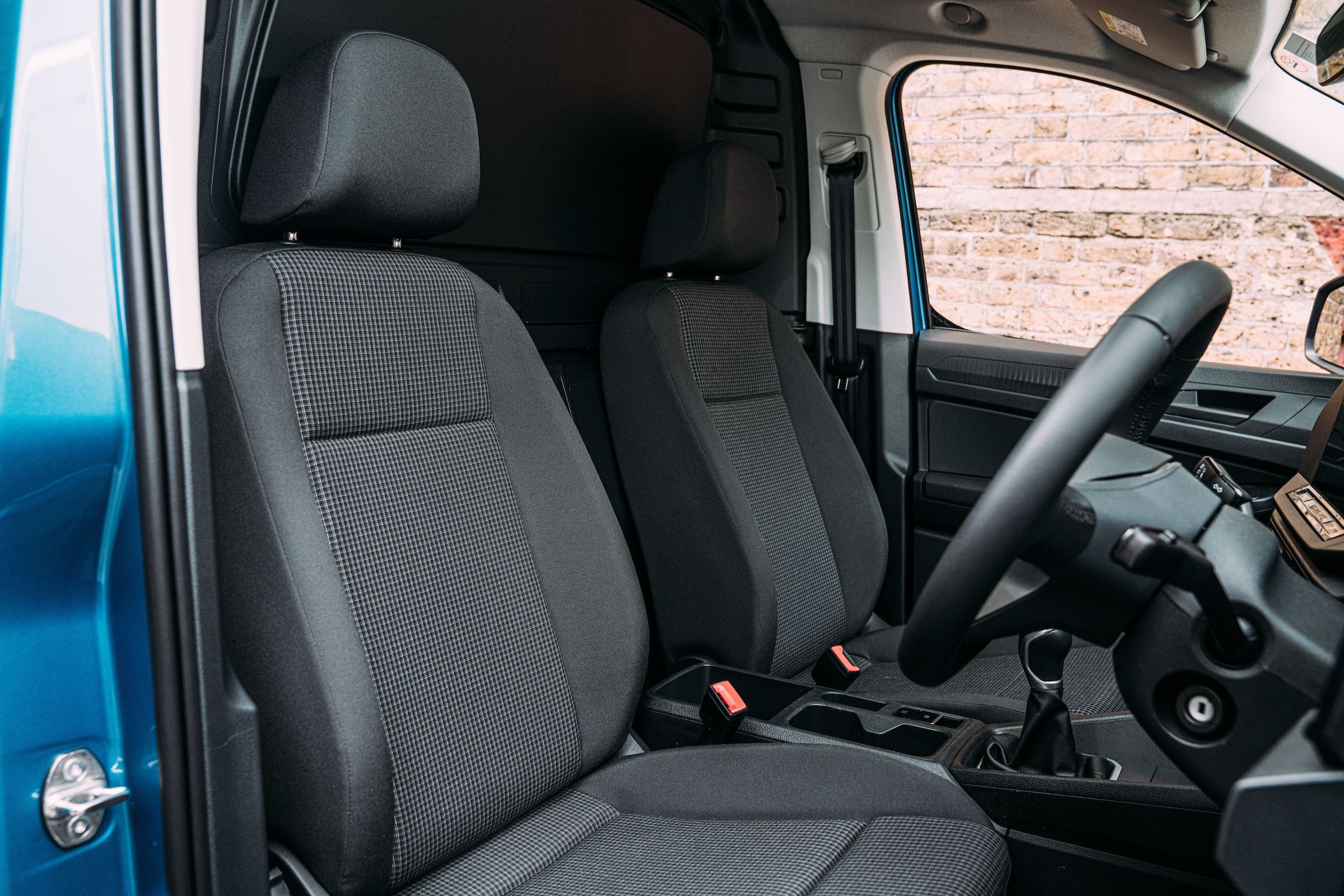Interior view of the new Volkswagen Caddy in blue, close-up of the front passenger seats