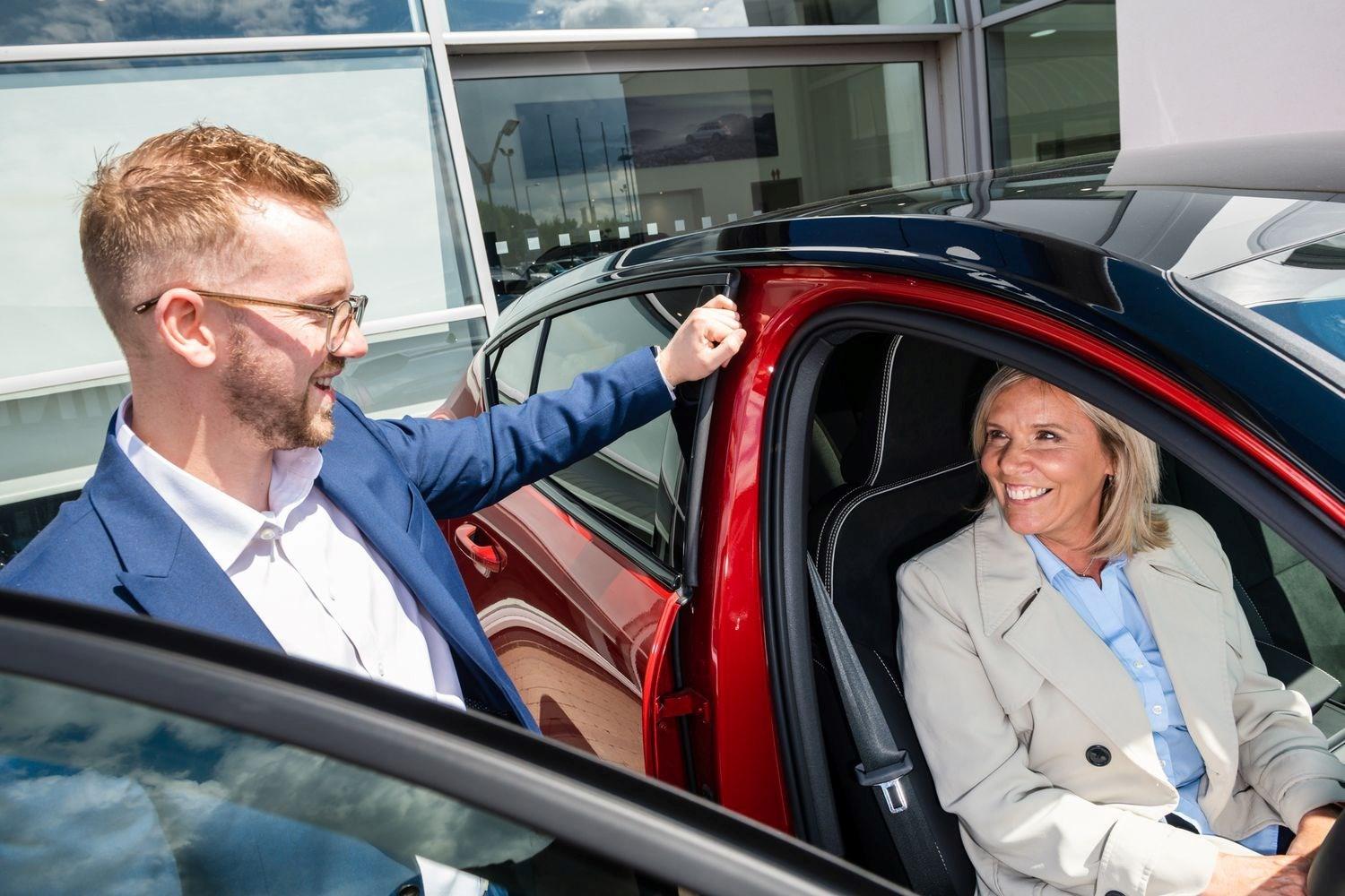 Agnew Belfast Volvo customer sits inside of red used Volvo XC40 while chatting to the Volvo Sales Specialist
